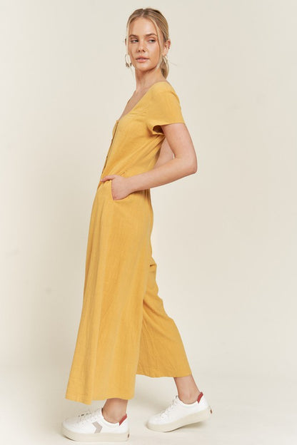 Mustard Seona Linen Plus Size Jumpsuit side view showing relaxed sleeves and side pockets.