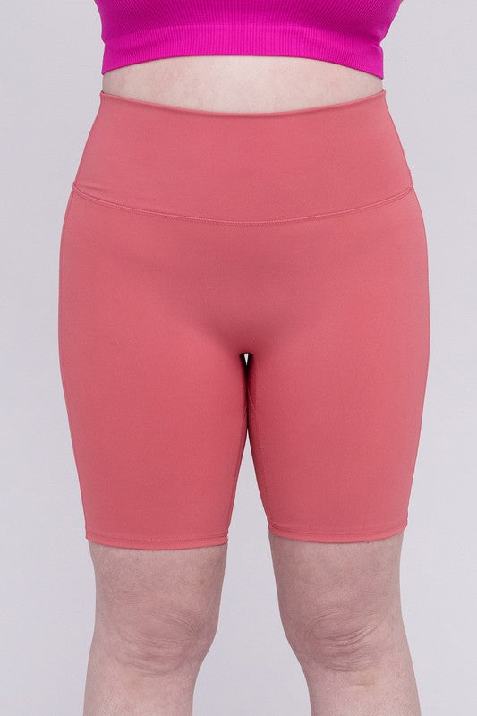 High-rise plus-size athletic biker shorts in desert rose, featuring a fitted silhouette and seamless design for comfort and flexibility.