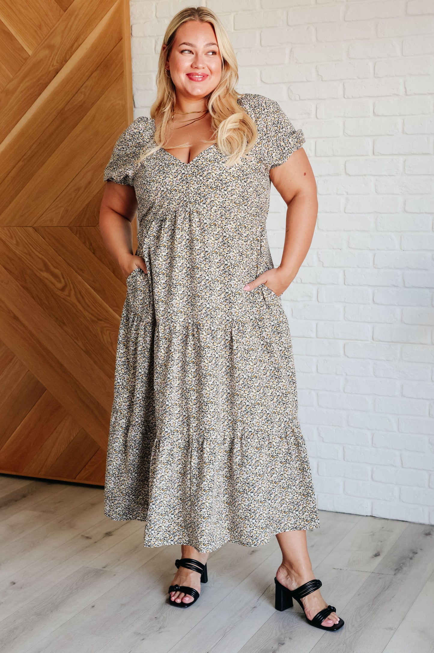 A maxi dress with a sweetheart neckline, short balloon sleeves, and a tiered skirt. Made from soft woven poplin with cased elastic details and functional side pockets.