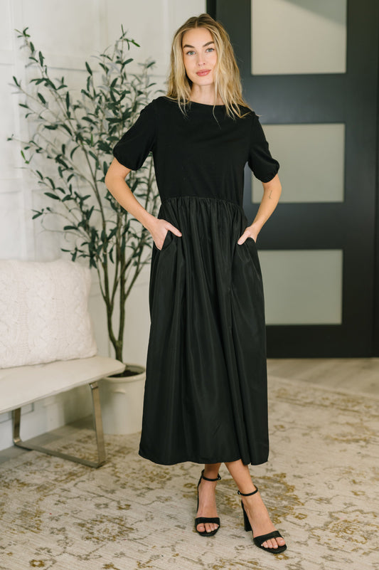Model wearing Adele Contrast Midi Black Dress with jersey knit bodice and woven midi skirt.