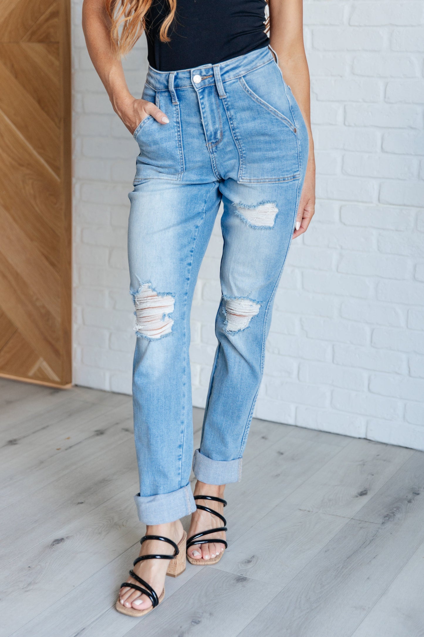 Light wash high-rise boyfriend jeans with patch pockets, distressed details, and optional cuffed hem