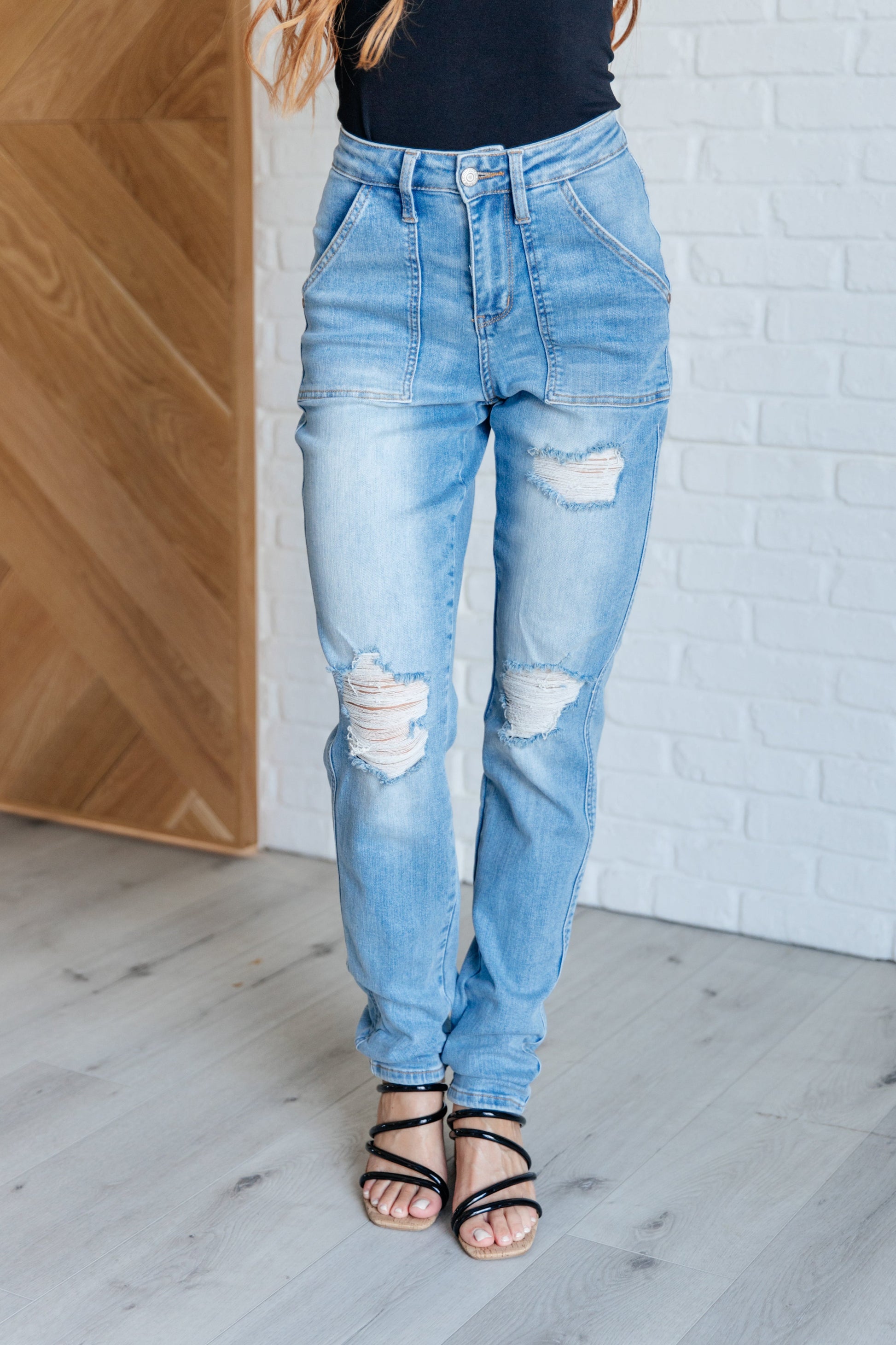 Light wash high-rise boyfriend jeans with patch pockets, distressed details, and optional cuffed hem