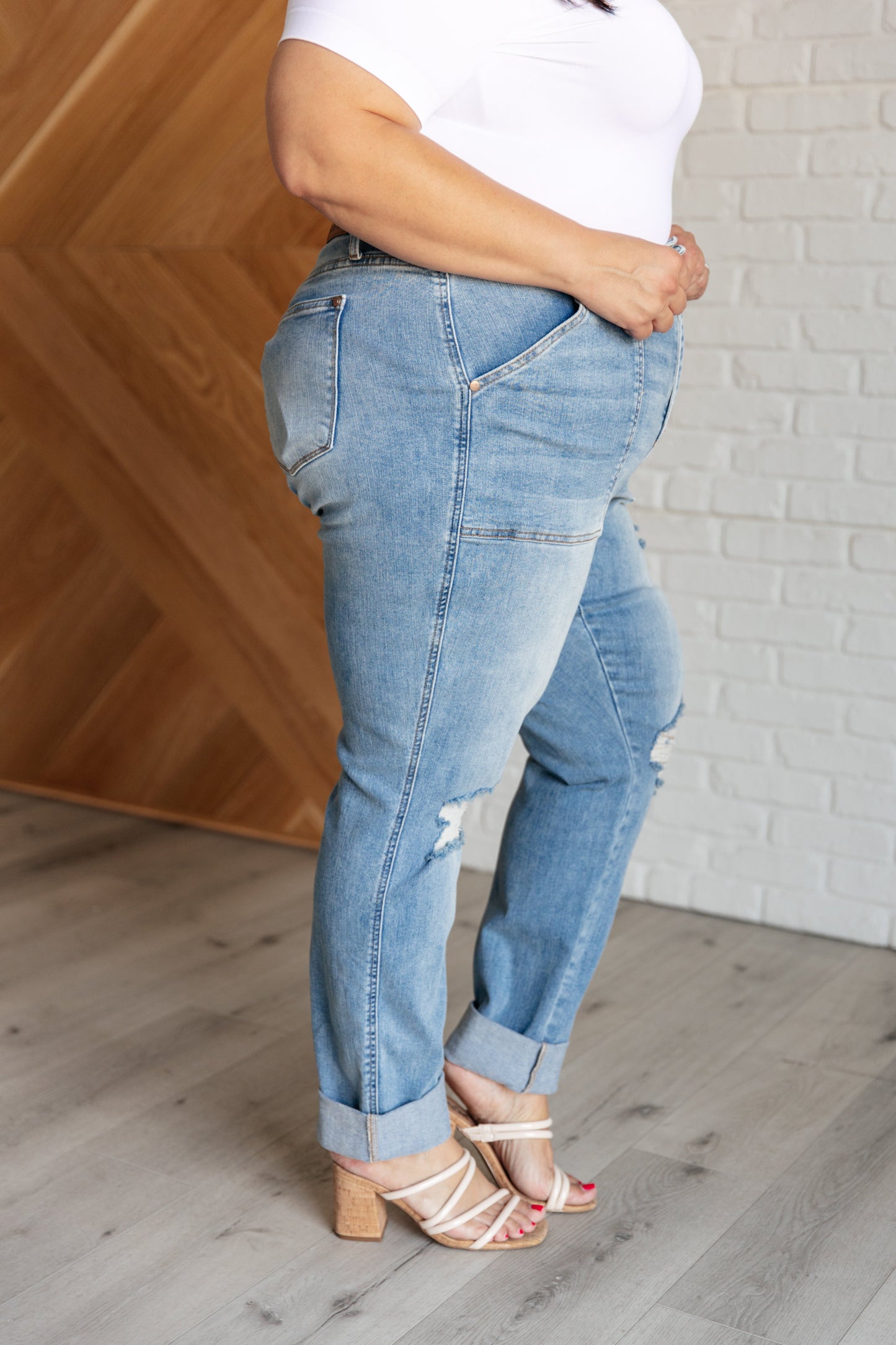 Light wash high-rise boyfriend jeans with patch pockets, distressed details, and optional cuffed hem