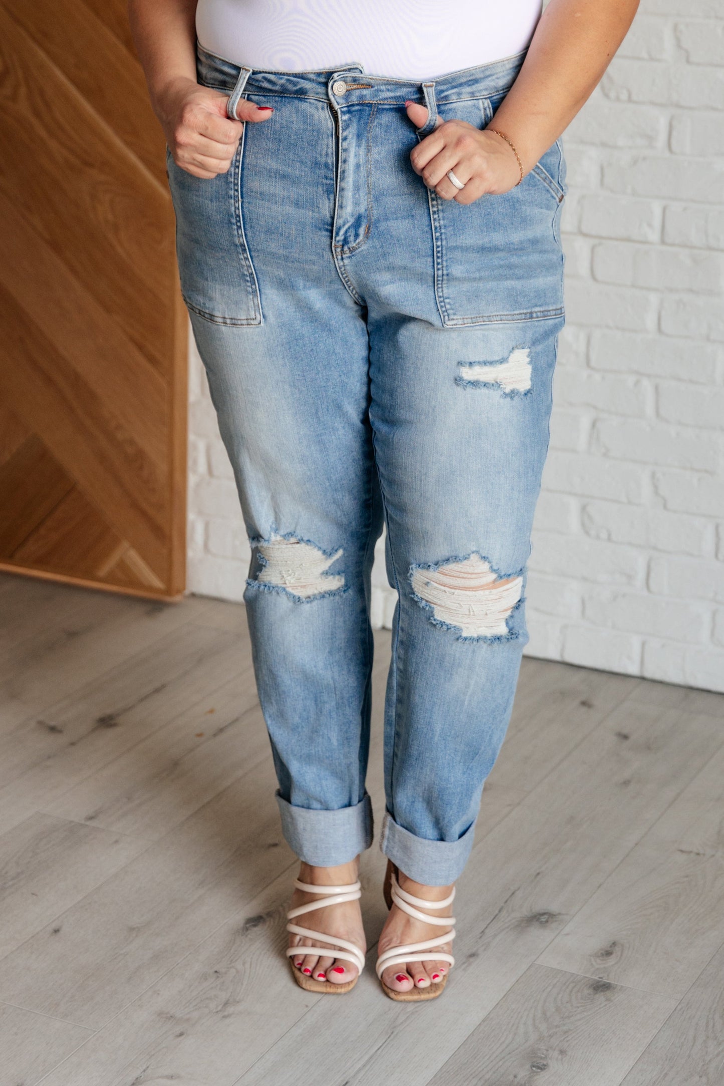 Light wash high-rise boyfriend jeans with patch pockets, distressed details, and optional cuffed hem