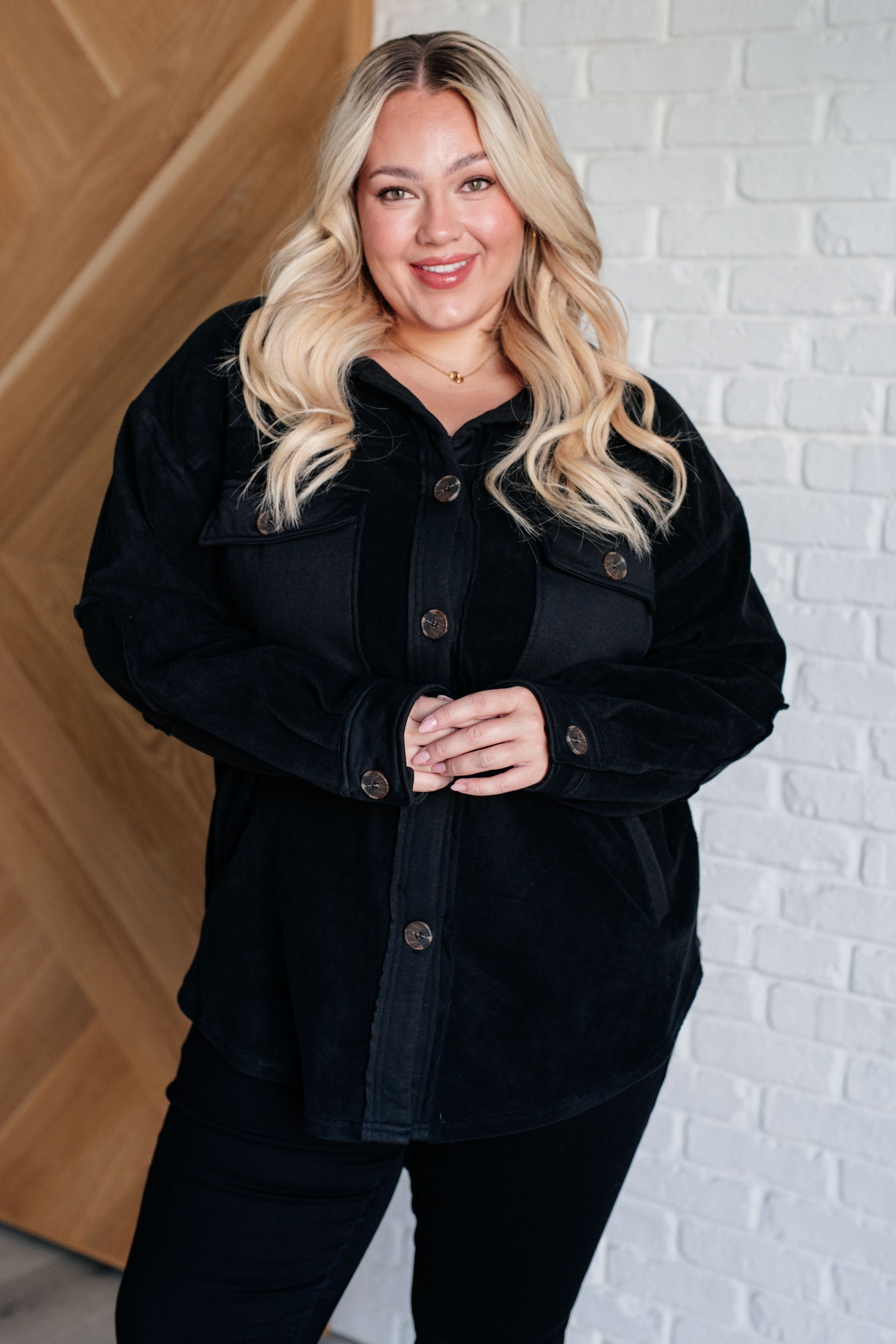 Plus size model wearing Akeelah Fleece Jacket in black with button front.