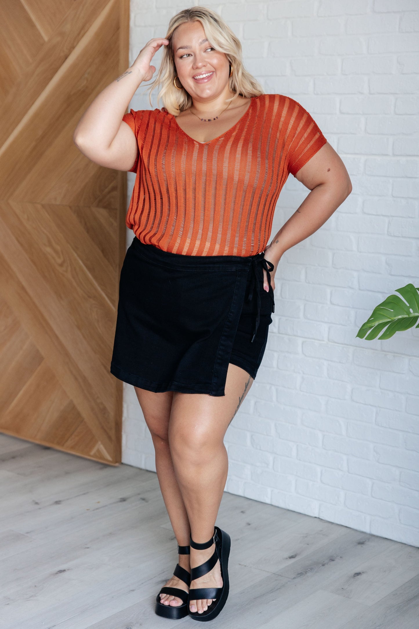 Plus size Aaliyah Loose Knit Top in burnt orange with a wide v-neckline, short sleeves, and a lightweight open knit stripe pattern. A cozy and stylish sweater knit design.