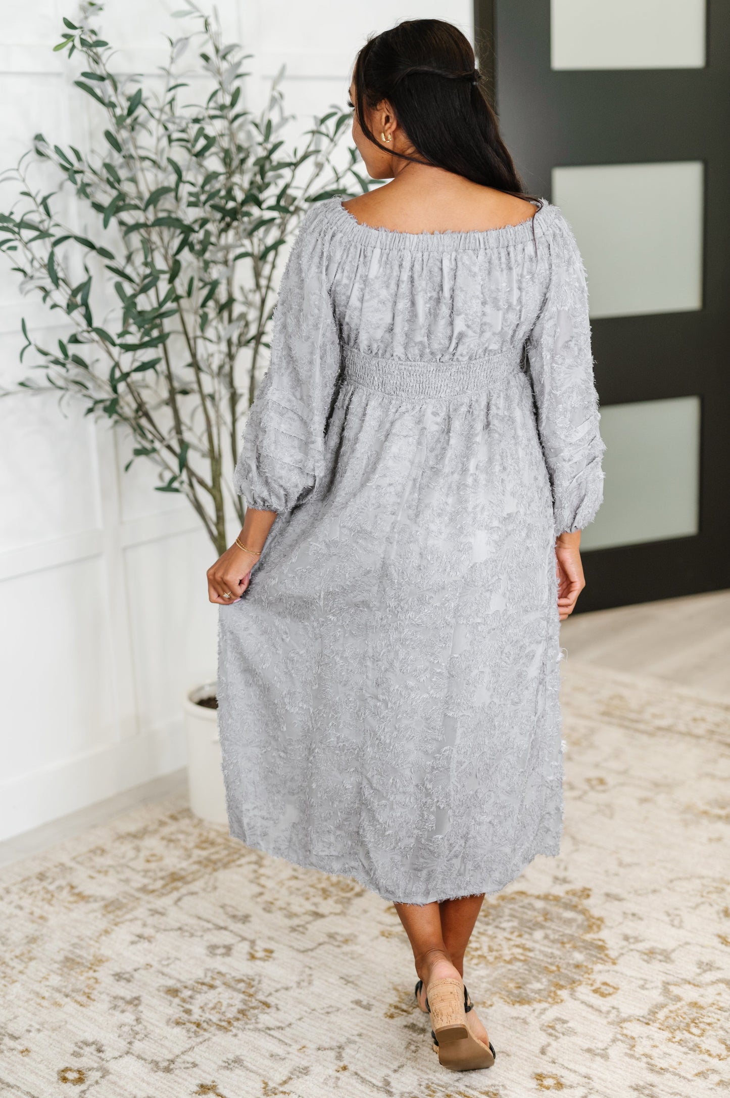 Back view of Janelle Off Shoulder Floral Chiffon Midi Dress with waist ruching and flowy chiffon overlay in soft lavender floral print.