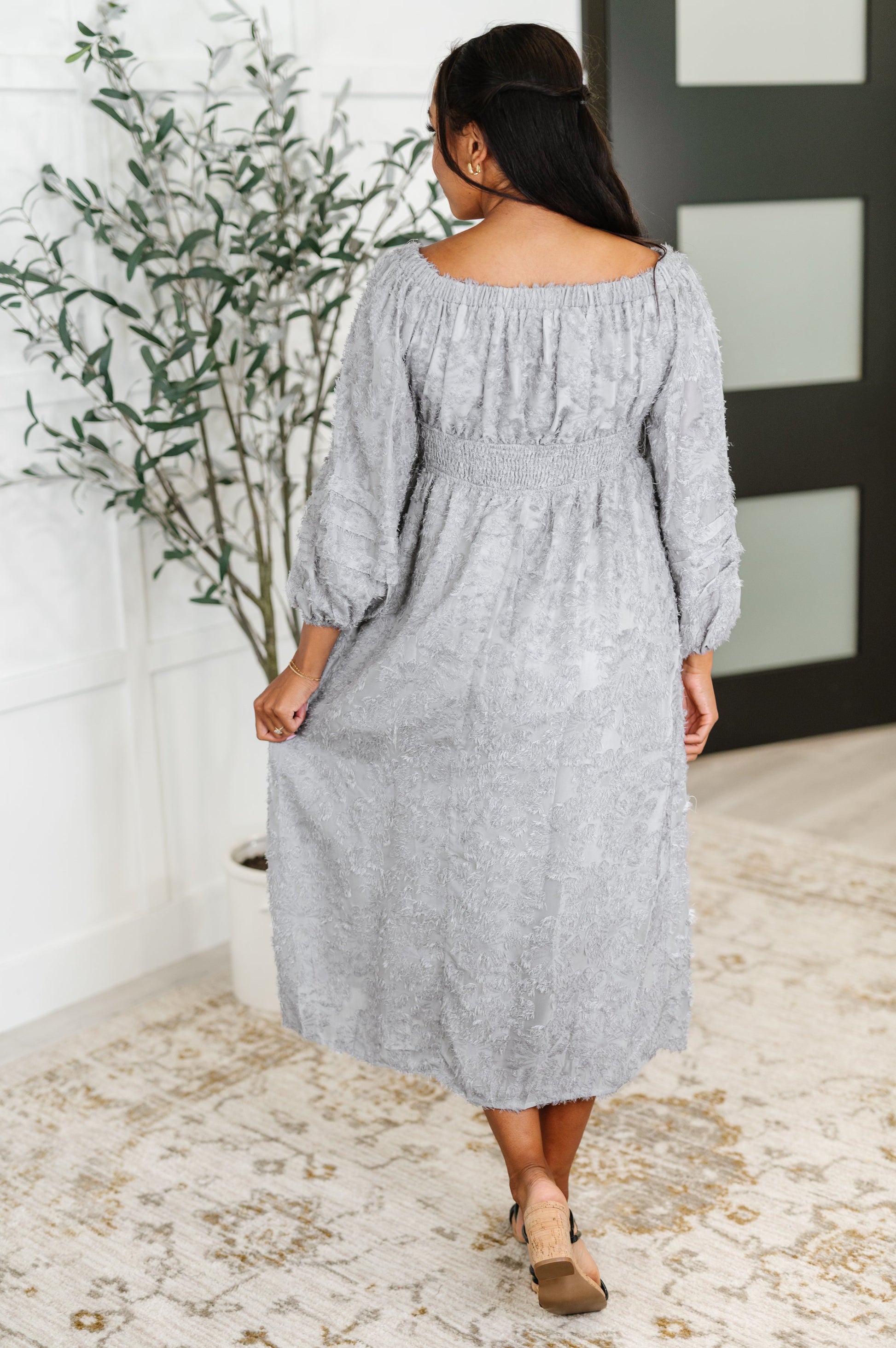 Back view of Janelle Off Shoulder Floral Chiffon Midi Dress with waist ruching and flowy chiffon overlay in soft lavender floral print.