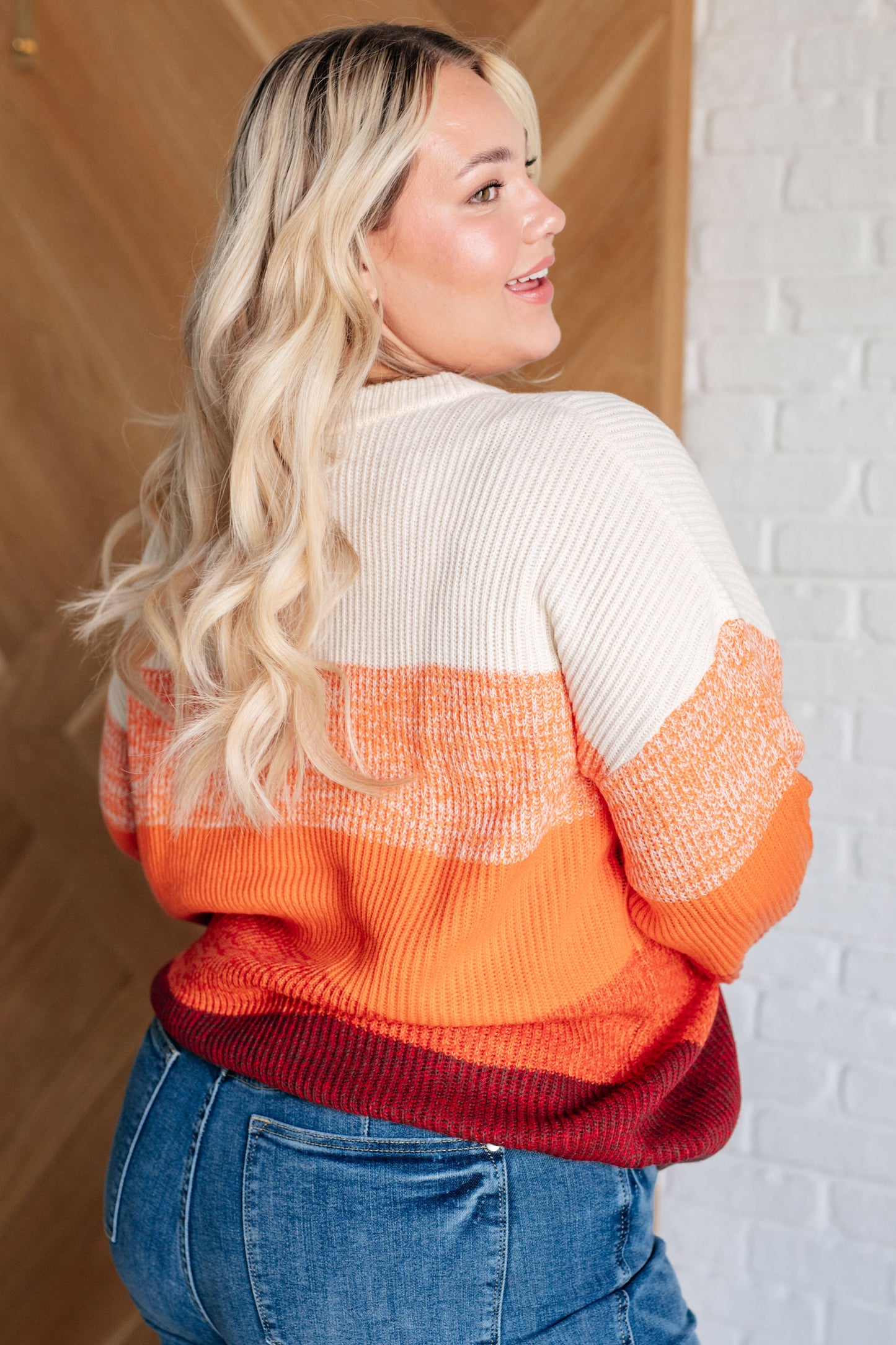 Women's oversized color block sweater with a banded ribbed round neckline, long drop-shoulder sleeves, and sweater knit fabric in white, peach, orange, red, and brown tones.