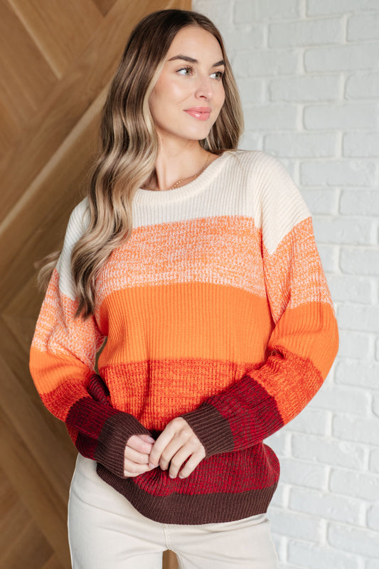 Women's oversized color block sweater with a banded ribbed round neckline, long drop-shoulder sleeves, and sweater knit fabric in white, peach, orange, red, and brown tones.