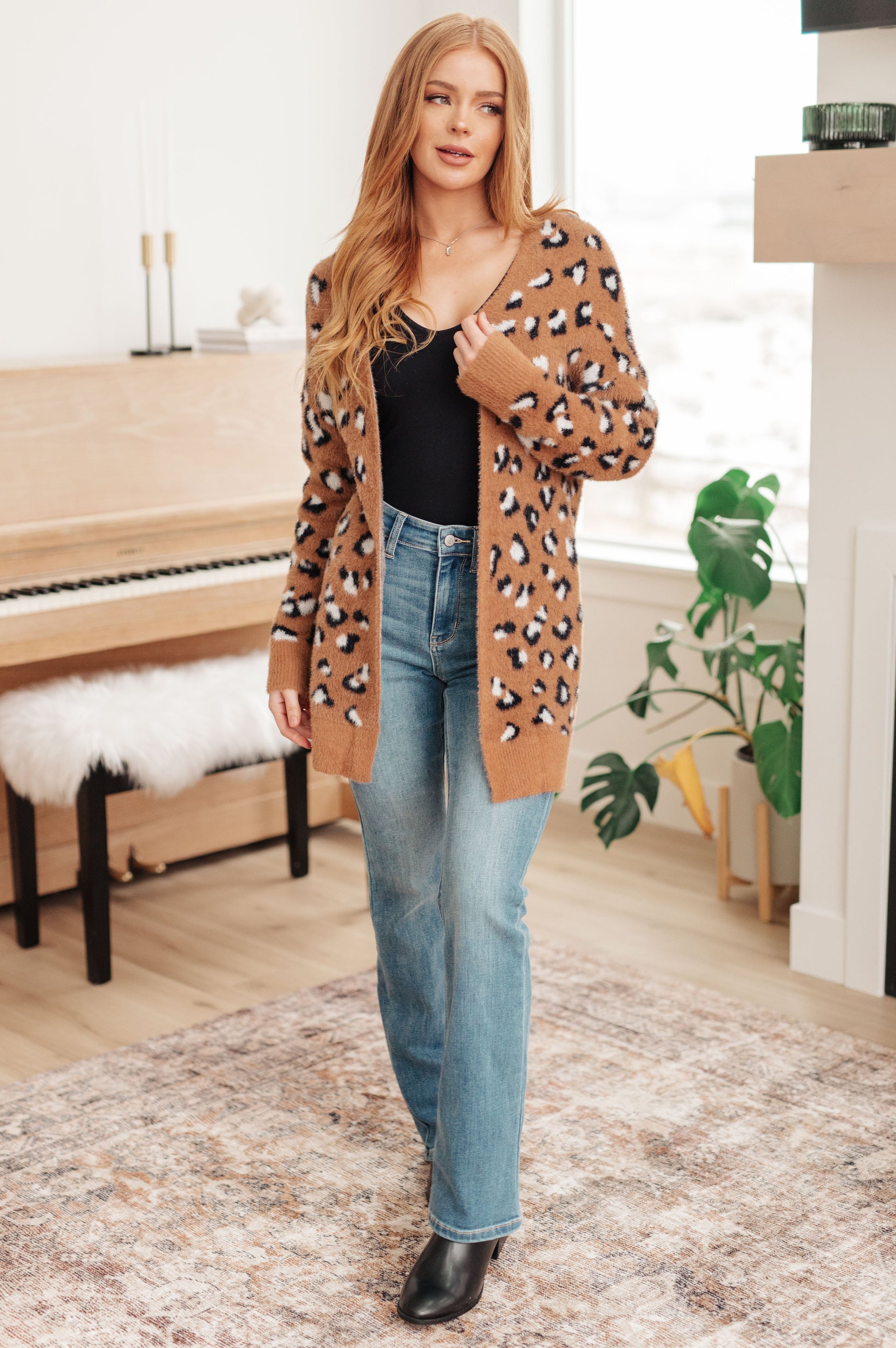 A women's longline cardigan in brown with a leopard print pattern, made from soft eyelash sweater knit fabric. Features an open front design, dropped shoulders, and long sleeves.