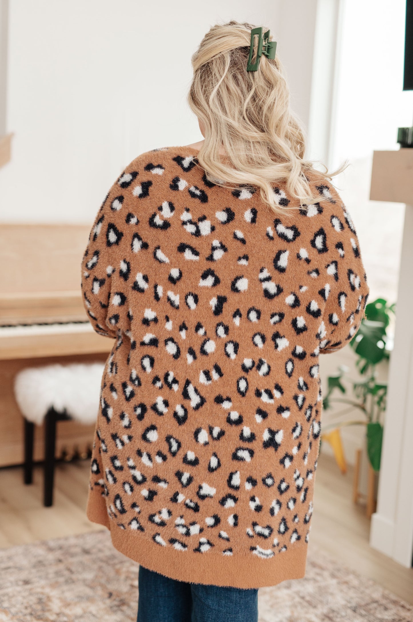 A women's longline cardigan in brown with a leopard print pattern, made from soft eyelash sweater knit fabric. Features an open front design, dropped shoulders, and long sleeves.