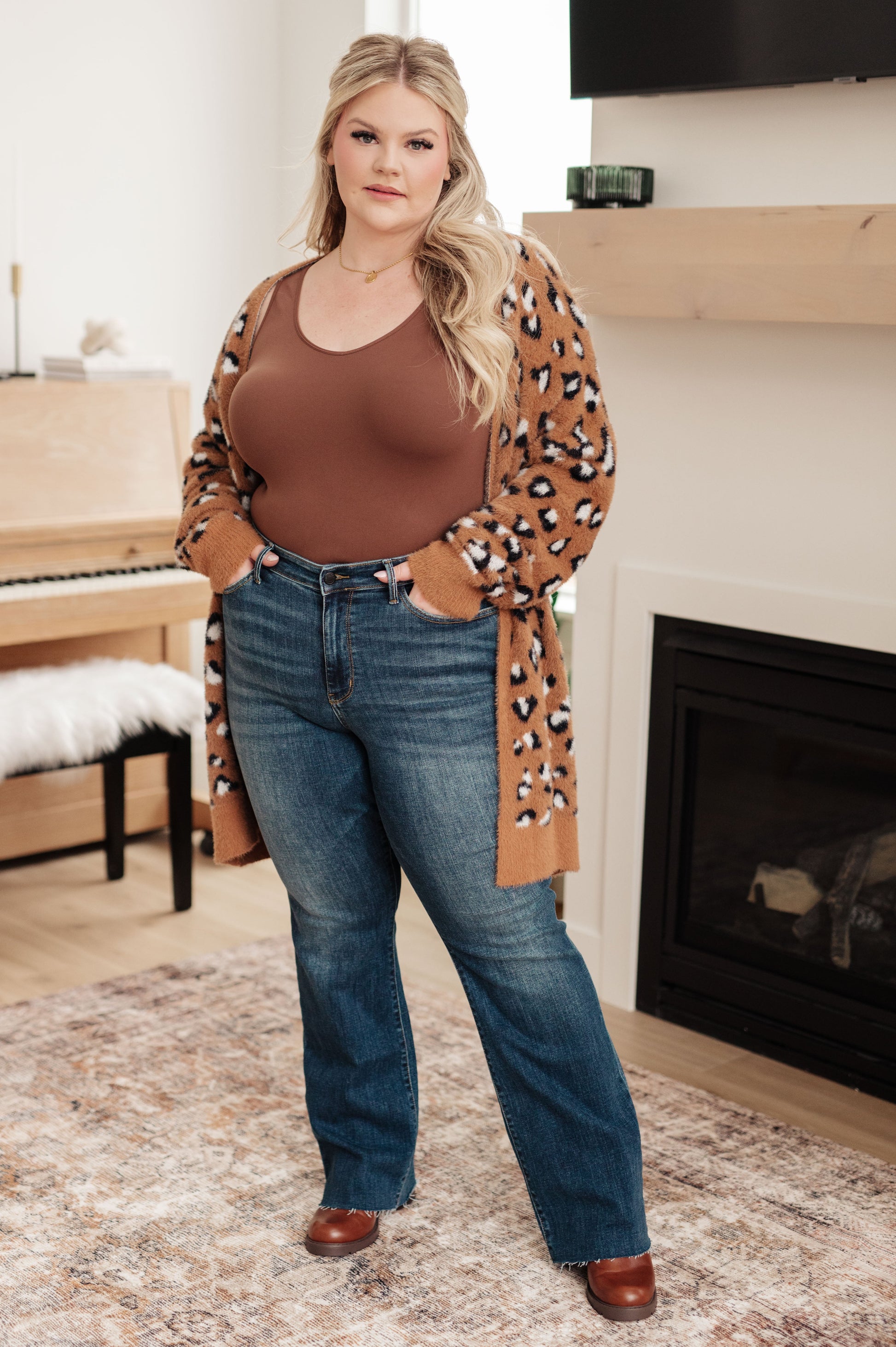 A women's longline cardigan in brown with a leopard print pattern, made from soft eyelash sweater knit fabric. Features an open front design, dropped shoulders, and long sleeves.