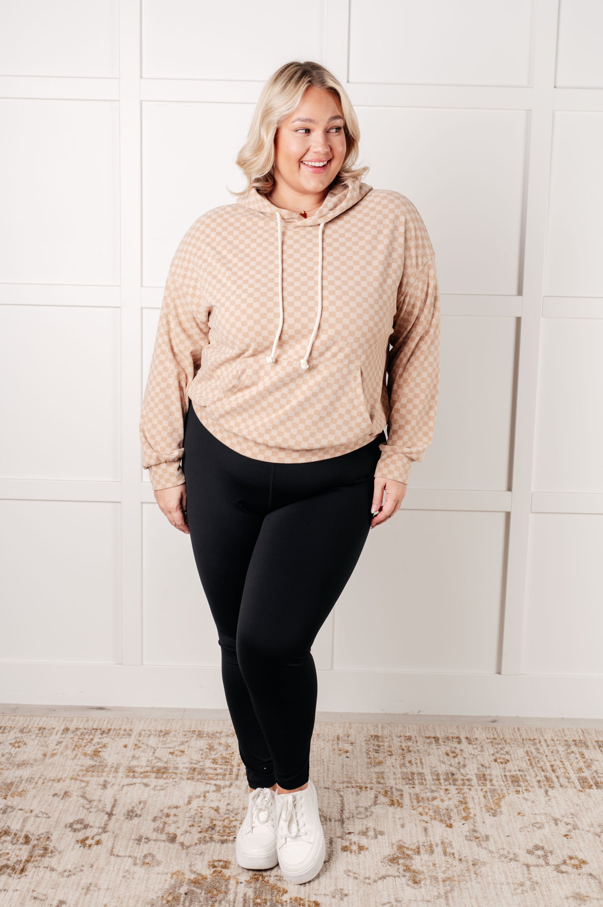 Plus size full body view of Dalia Checkered Hoodie in khaki paired with leggings and sneakers.