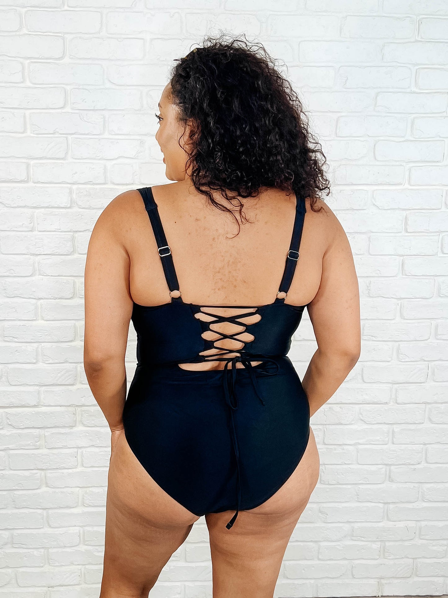 Back view plus size Barcelona lace-up swimsuit with silver hardware and cheeky fit for stylish swimwear looks.
