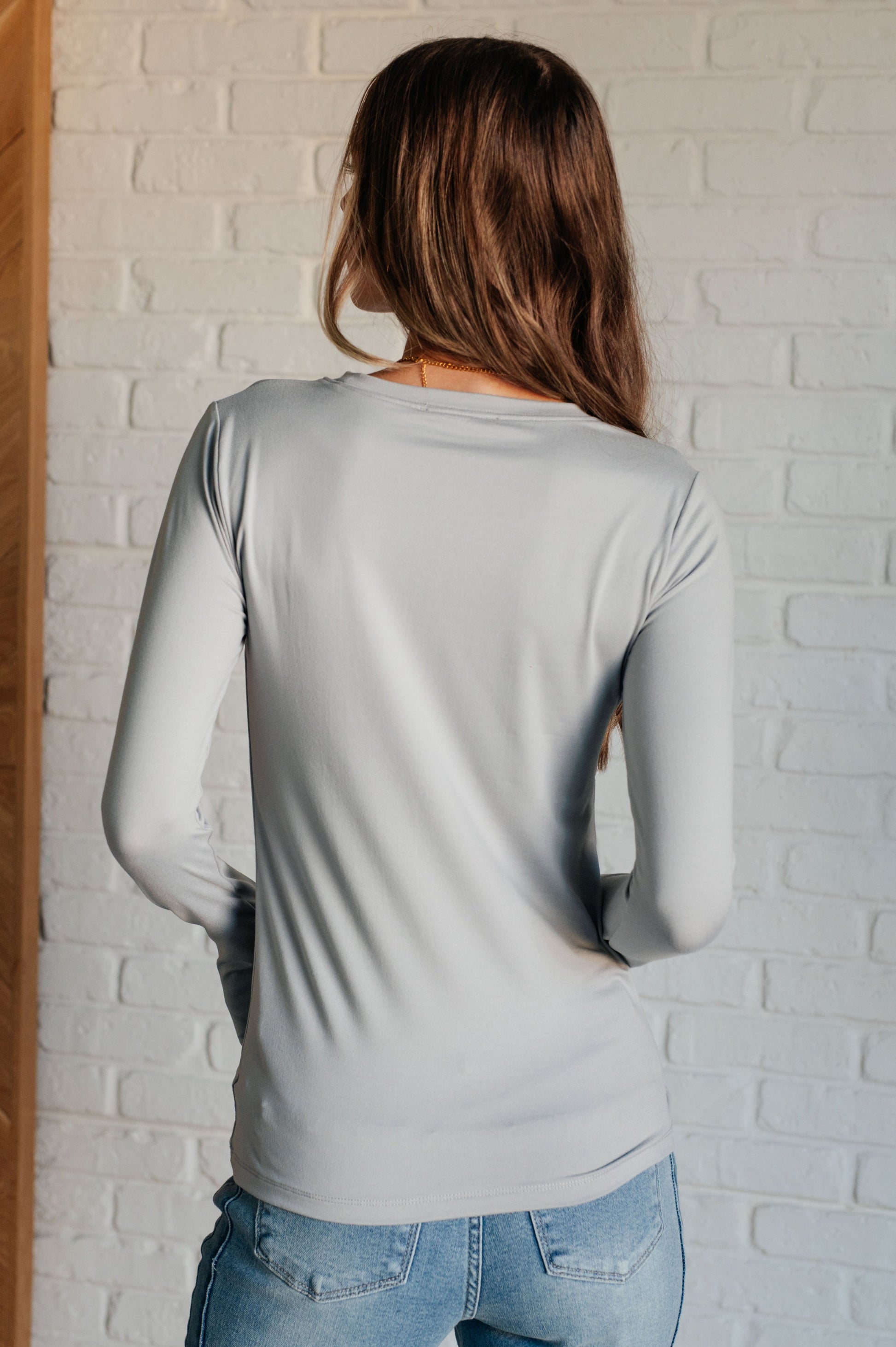 Light gray long-sleeve form-fitting tee made from brushed microfiber with a round neckline.