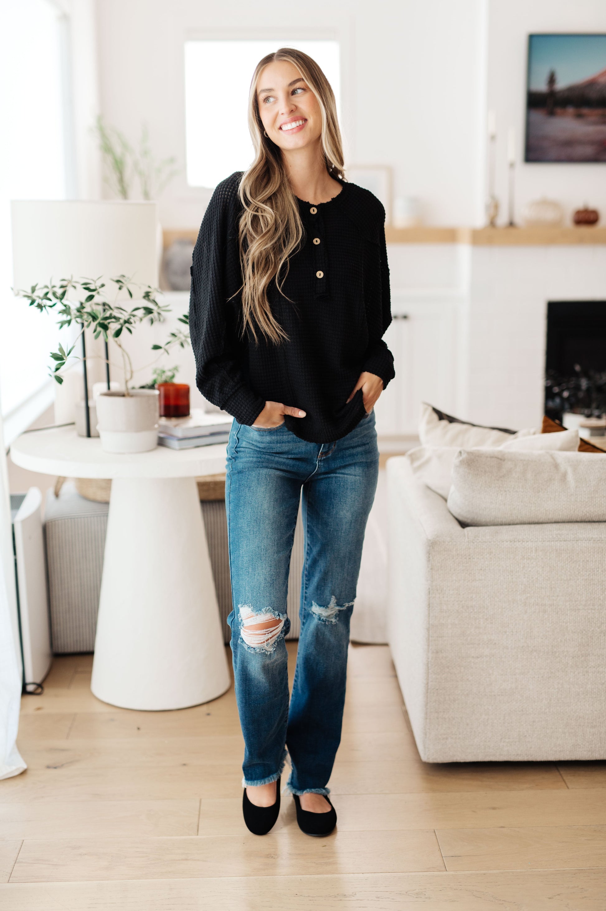 Bea Black Henley Top with button-up closure and raw seam detail styled for casual wear.
