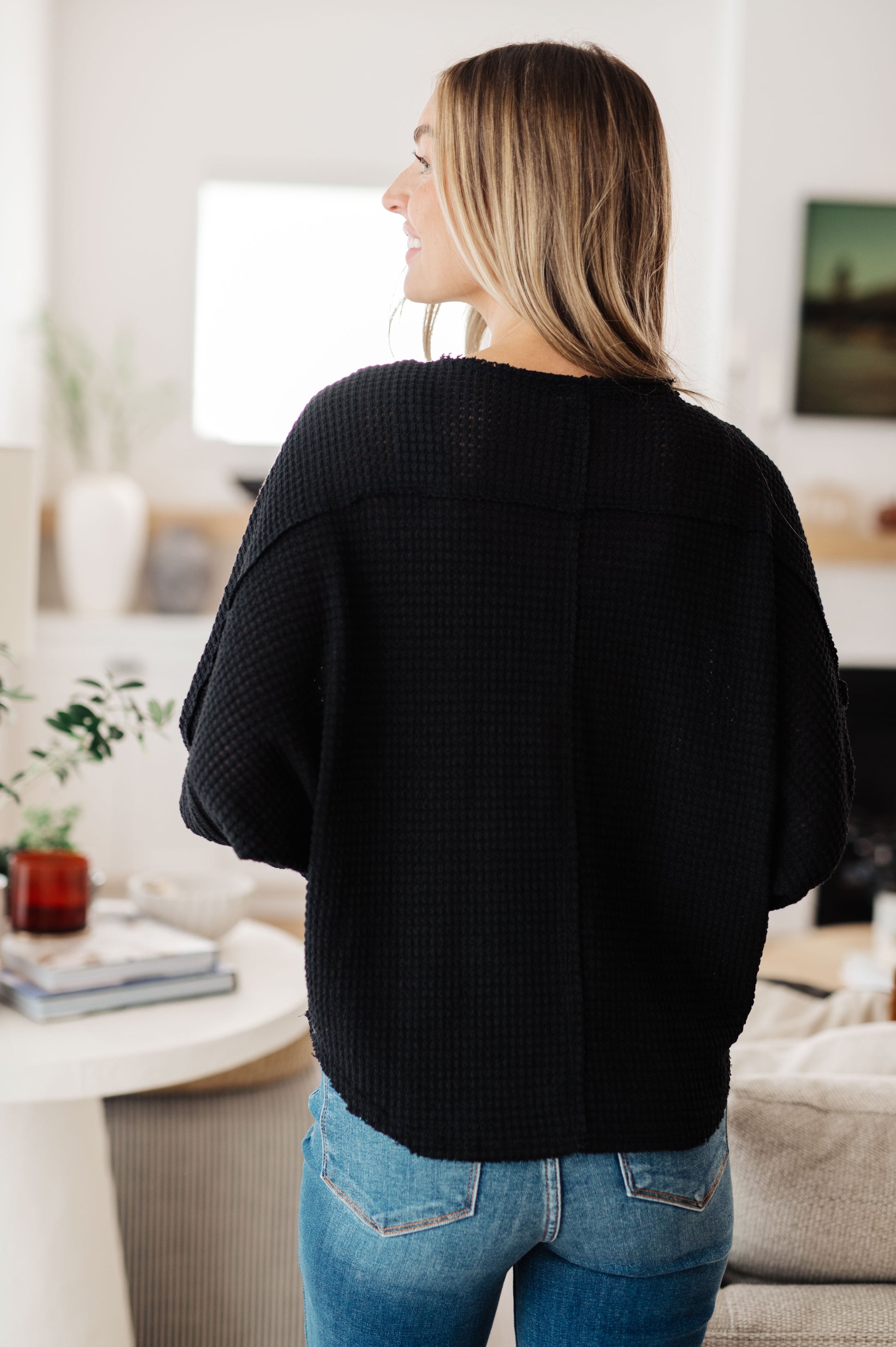 Back view of Bea Black Waffle Knit Henley Top with round neckline and cozy silhouette.