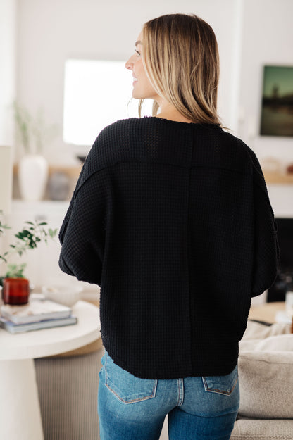 Back view of Bea Black Waffle Knit Henley Top with round neckline and cozy silhouette.