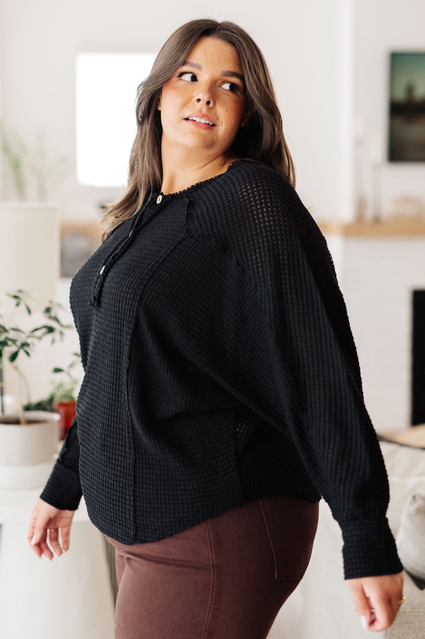 Side view of plus size Bea Black Henley Top with waffle knit texture and relaxed silhouette.
