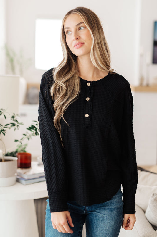 Front view of Bea Black Waffle Knit Henley Top with wooden buttons and raw seam detail.