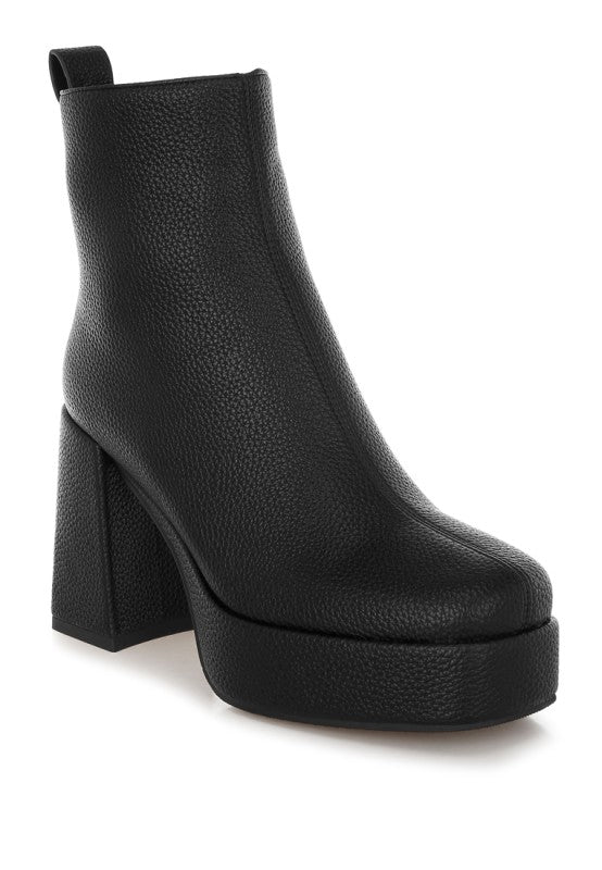 Black Poulin Chelsea Boots angled view with faux leather shine and block heel elevation.