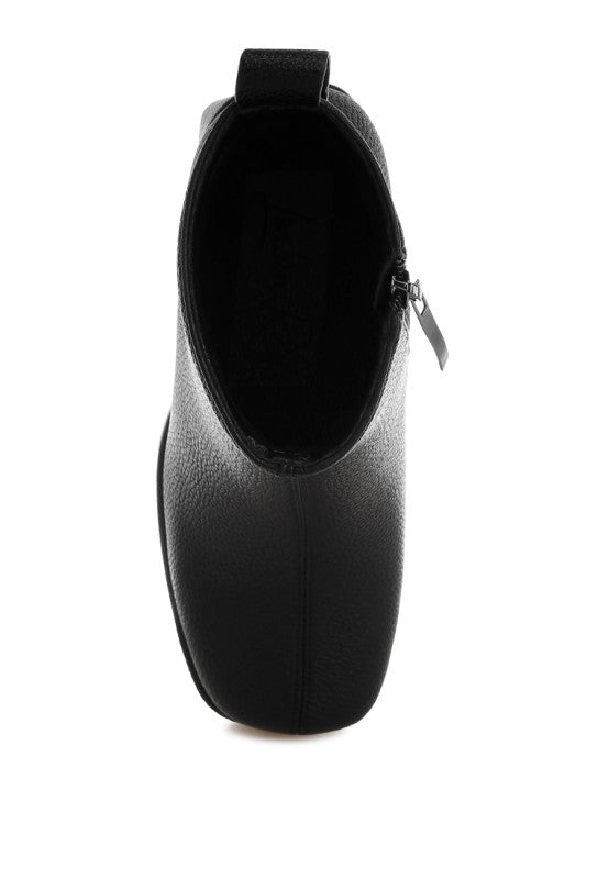Top angle of black Poulin Chelsea Boots showcasing zipper closure and polished finish.