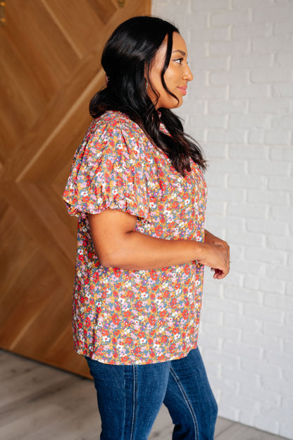 Plus size floral mock neck blouse with functional back tie and short balloon sleeves for breathable comfort.