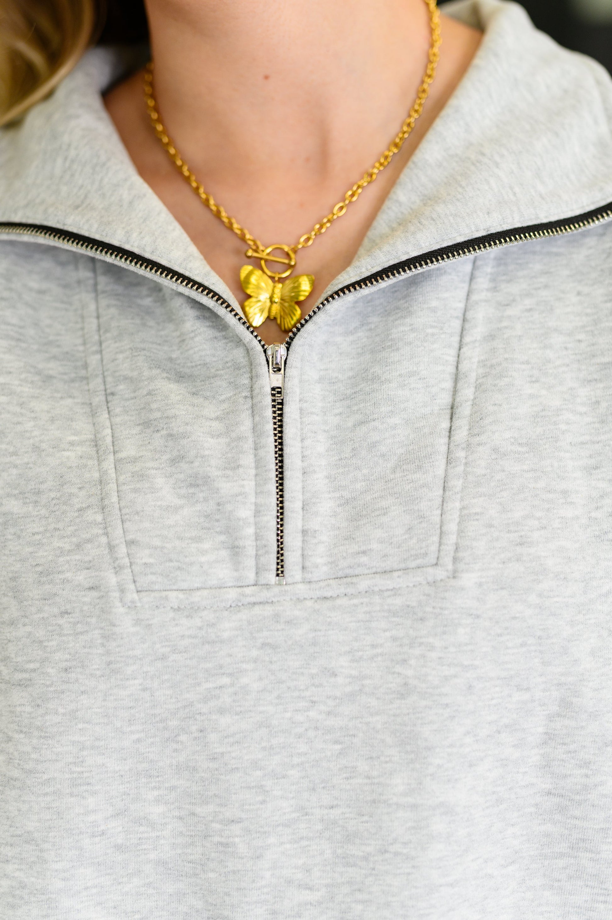 Close-up of silver half zipper closure on gray Bonny Half Zip Pullover regular size with fleece texture.