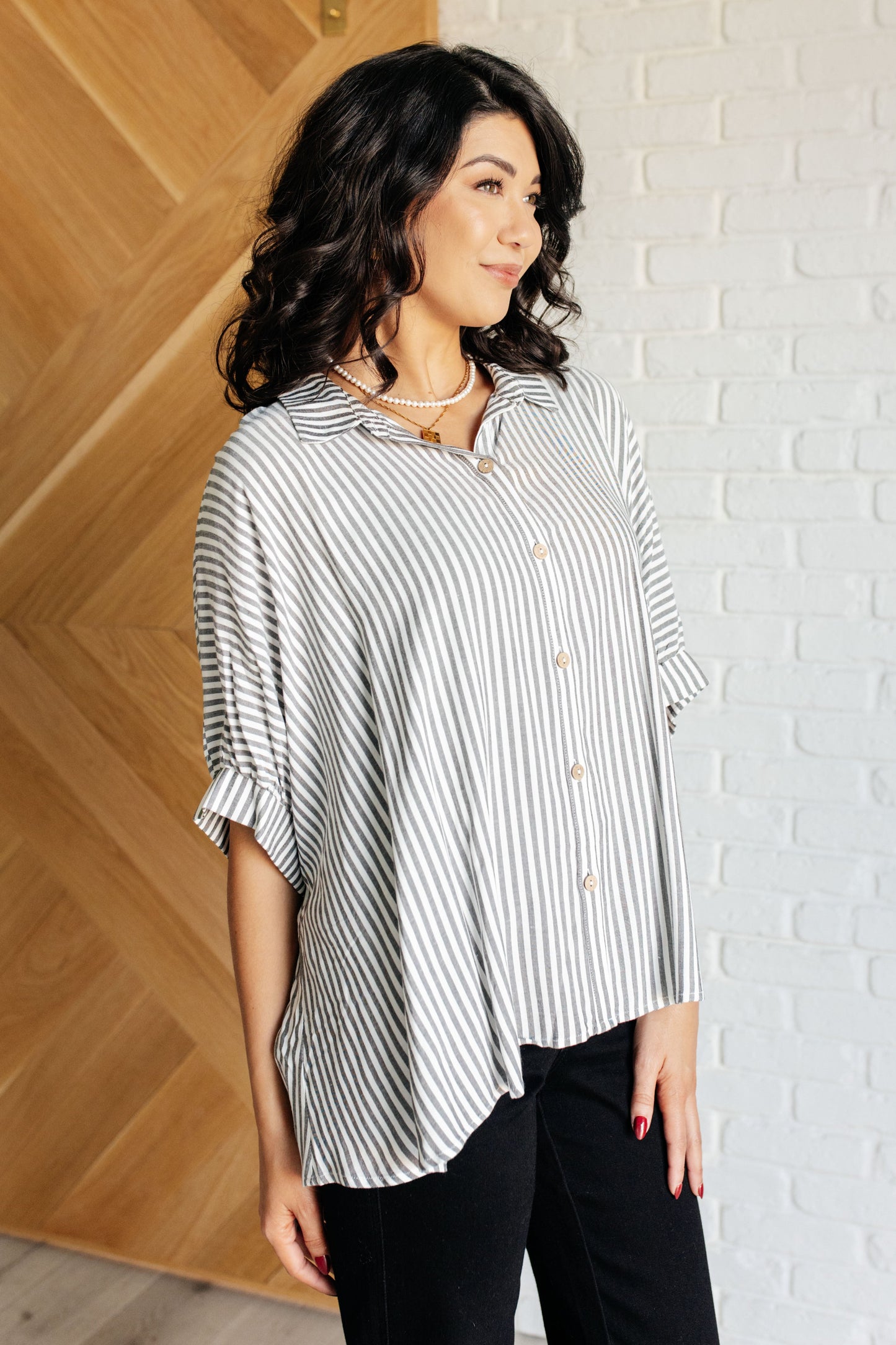 Women's button-up shirt in  white with black stripes, featuring a collared neckline, short dolman sleeves, banded cuffs, button closure, and a scooped hemline.