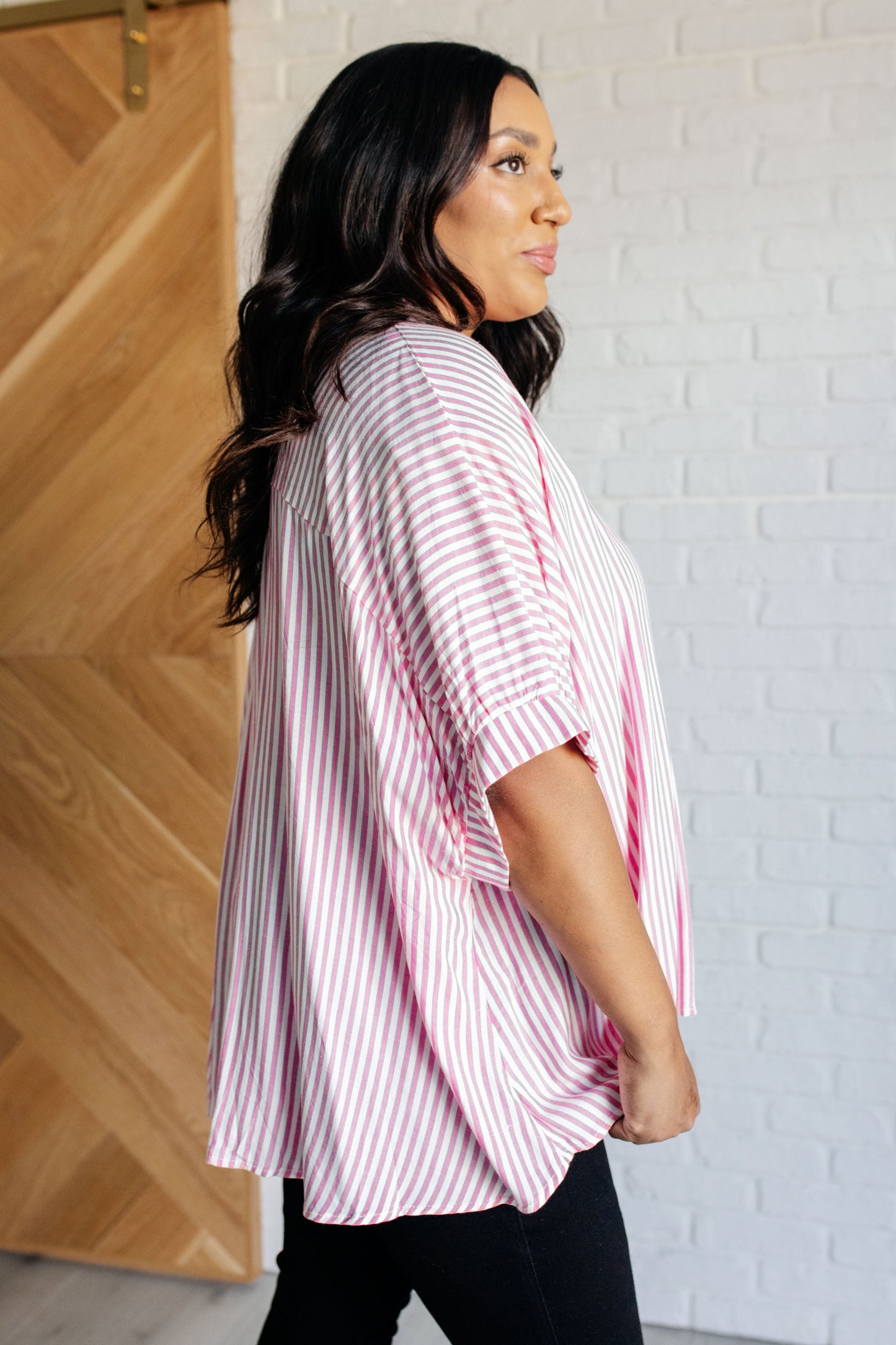 Women's button-up shirt in hot pink with white stripes, featuring a collared neckline, short dolman sleeves, banded cuffs, button closure, and a scooped hemline.