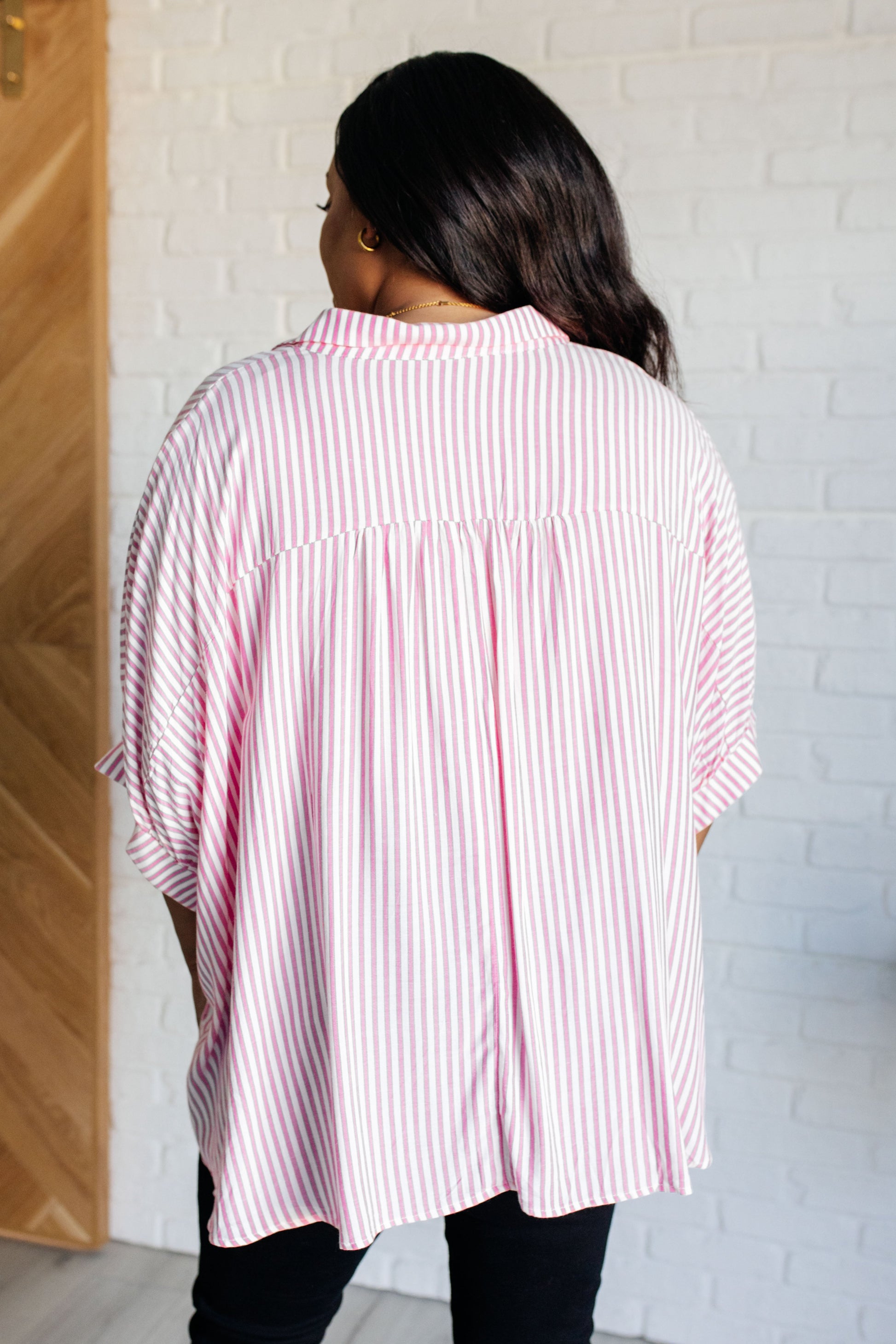 Women's button-up shirt in hot pink with white stripes, featuring a collared neckline, short dolman sleeves, banded cuffs, button closure, and a scooped hemline.