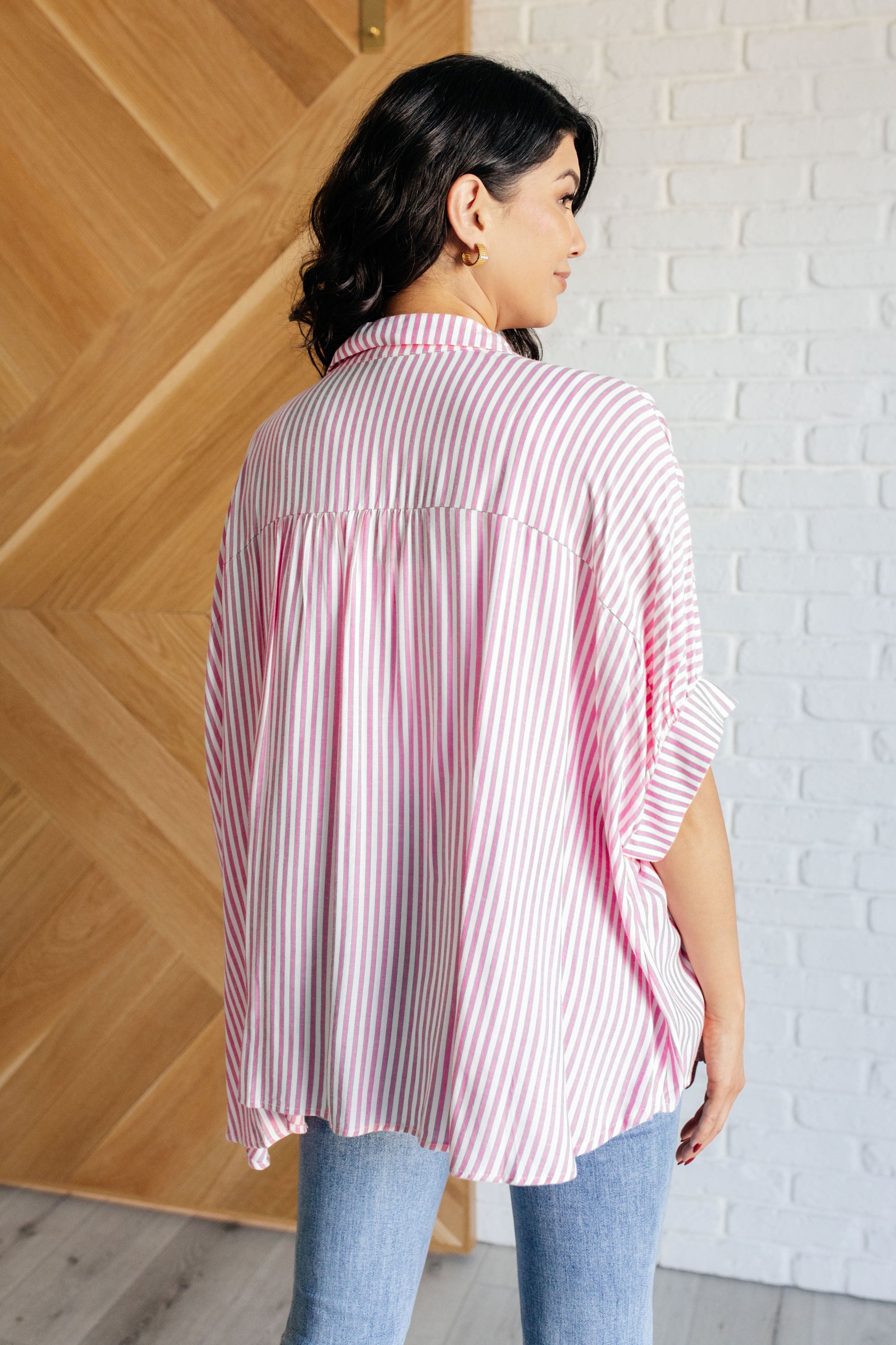 Women's button-up shirt in hot pink with white stripes, featuring a collared neckline, short dolman sleeves, banded cuffs, button closure, and a scooped hemline.