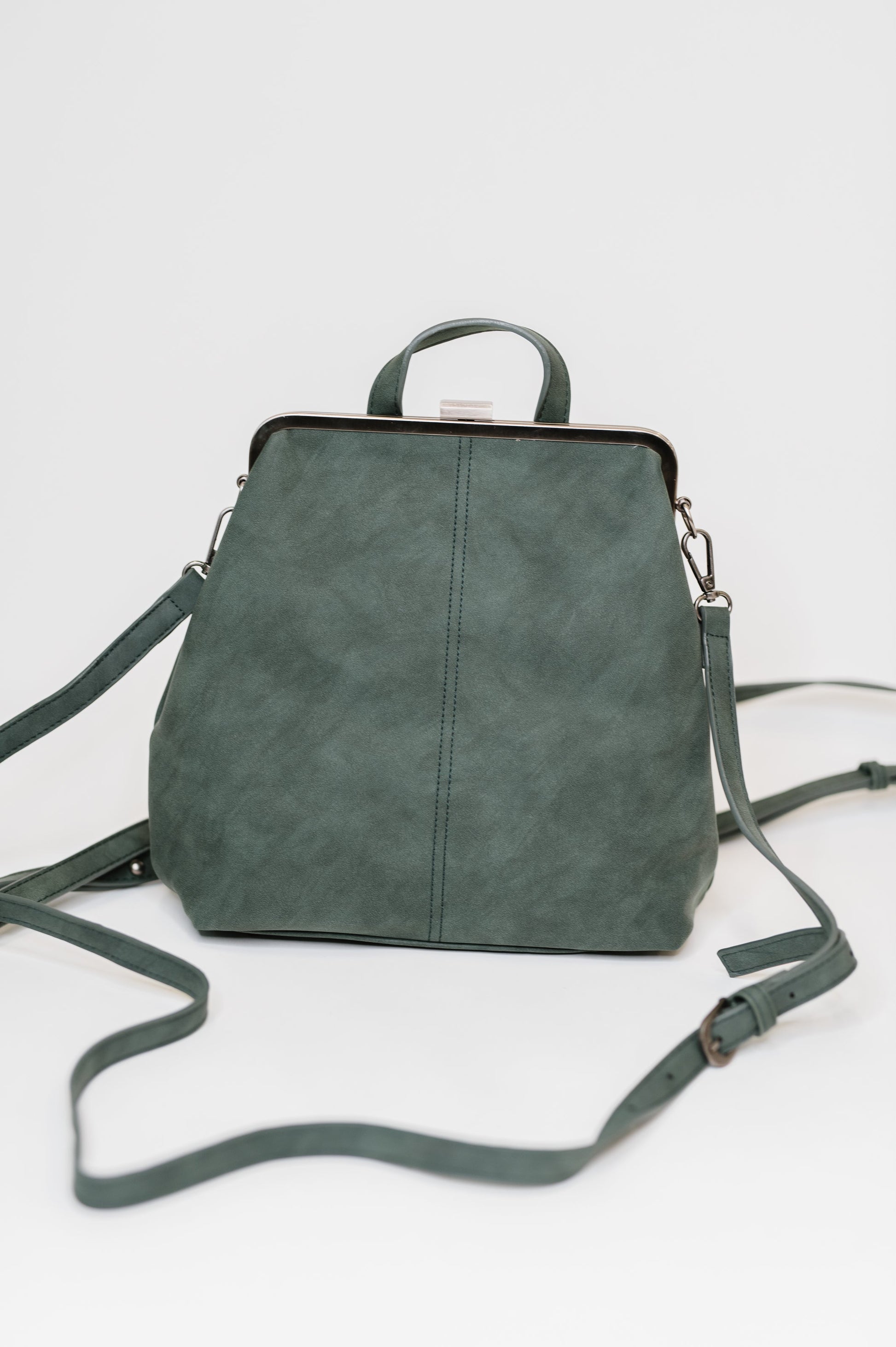 Bridget Backpack in Peacock, vegan leather with brass clasp closure, displayed on flat surface.