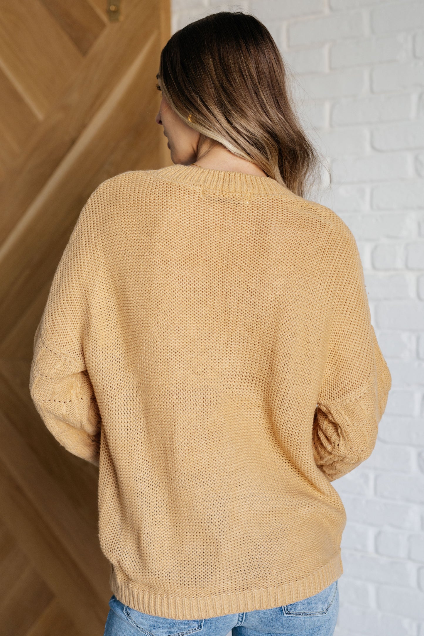 Women's wheat-colored sweater made of sweater knit fabric, featuring a round neckline, long balloon sleeves with drop shoulders, and banded ribbed cuffs, neckline, and hem.