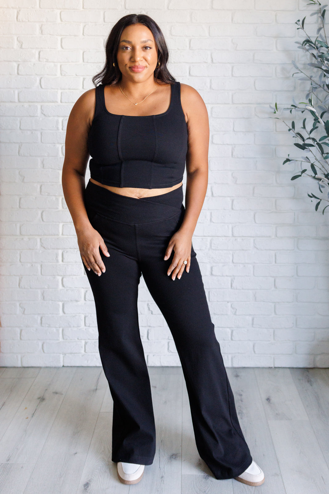 Twill Flared Crossover Waist Pants in Black with a high V-waistline, medium-stretch fabric, flared legs, and functional front and back pockets.