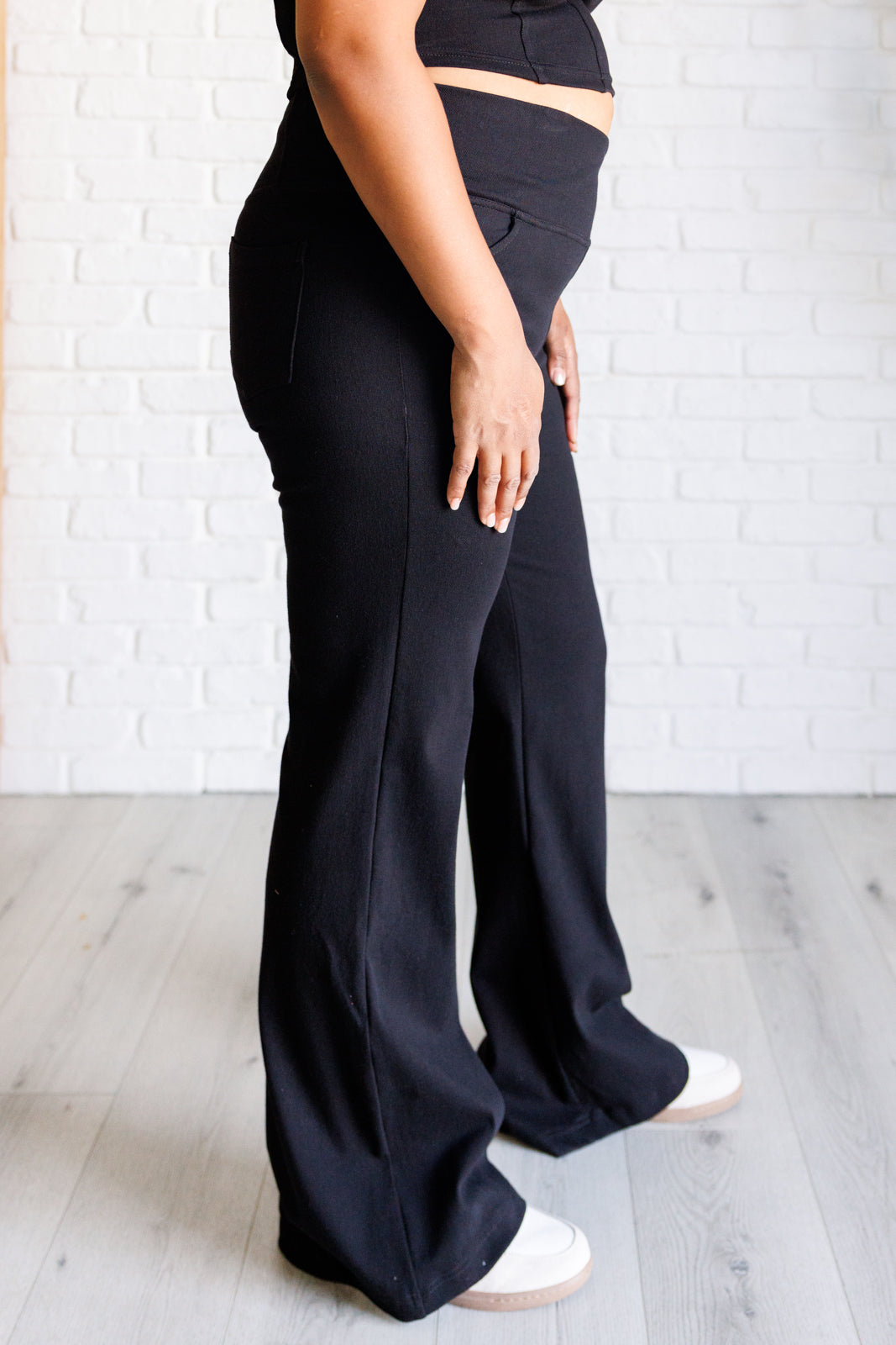 Twill Flared Crossover Waist Pants in Black with a high V-waistline, medium-stretch fabric, flared legs, and functional front and back pockets.