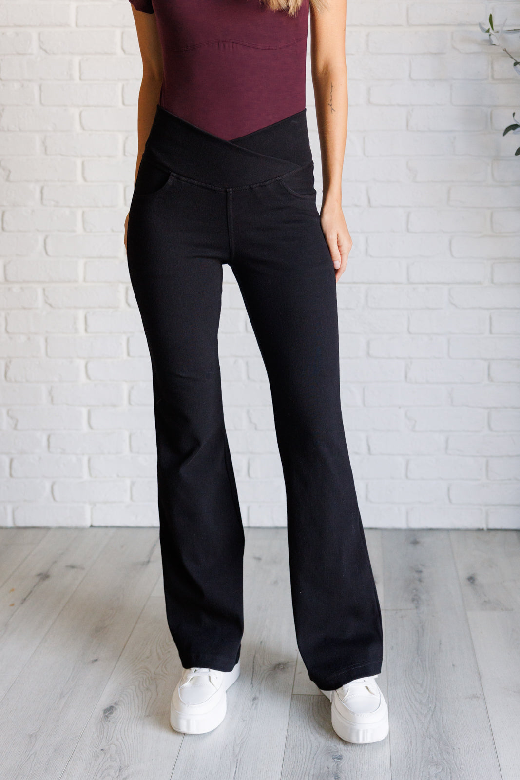 Twill Flared Crossover Waist Pants in Black with a high V-waistline, medium-stretch fabric, flared legs, and functional front and back pockets.