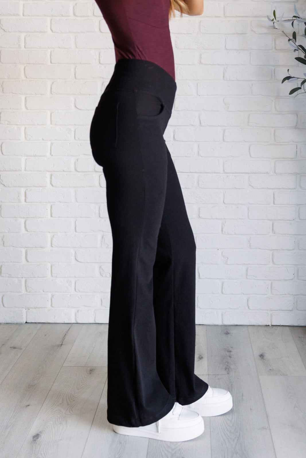 Twill Flared Crossover Waist Pants in Black with a high V-waistline, medium-stretch fabric, flared legs, and functional front and back pockets.