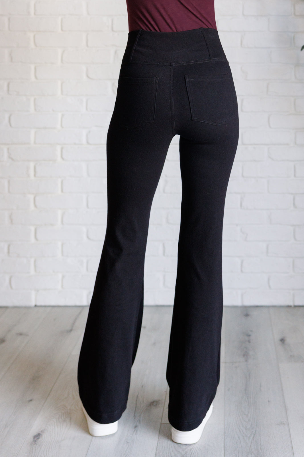 Twill Flared Crossover Waist Pants in Black with a high V-waistline, medium-stretch fabric, flared legs, and functional front and back pockets.