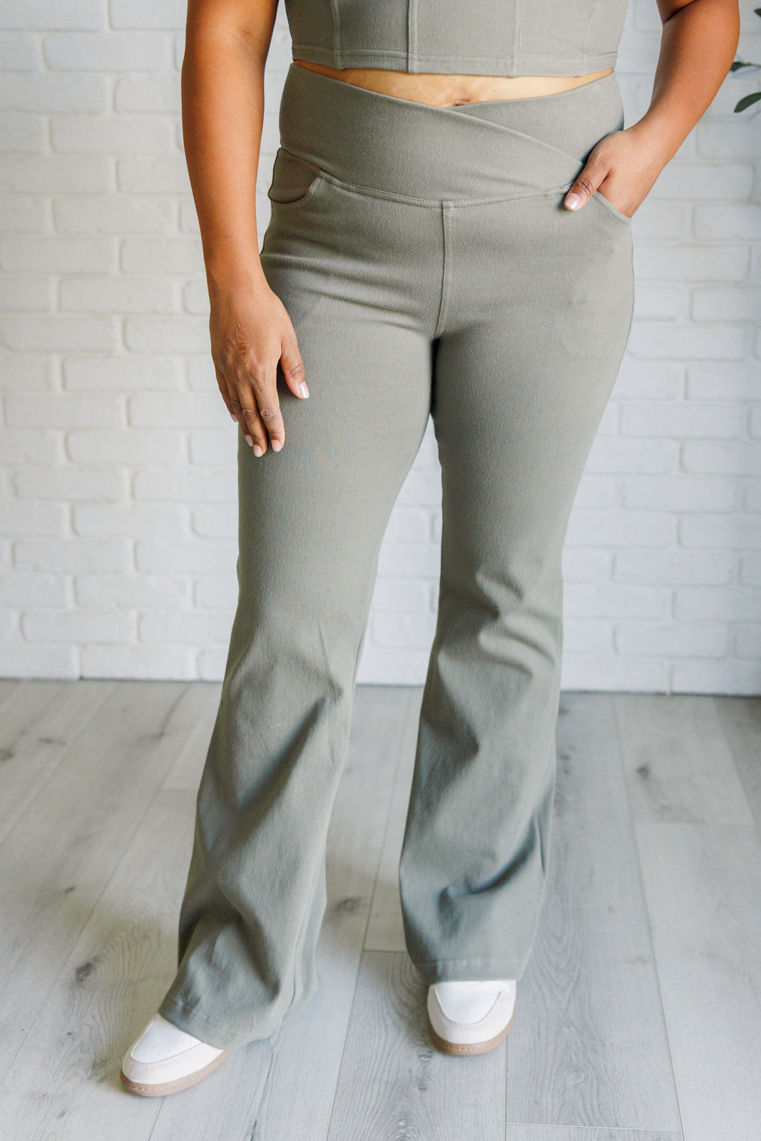 Twill Flared Crossover Waist Pants in dusty olive with a high V-waistline, medium-stretch fabric, flared legs, and functional front and back pockets.