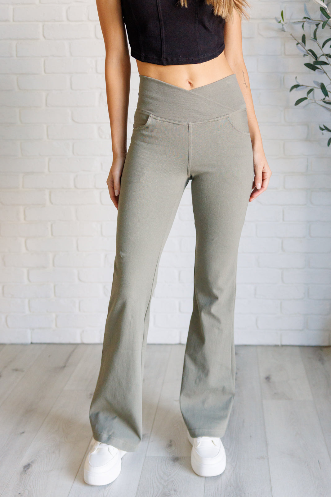 Twill Flared Crossover Waist Pants in dusty olive with a high V-waistline, medium-stretch fabric, flared legs, and functional front and back pockets.