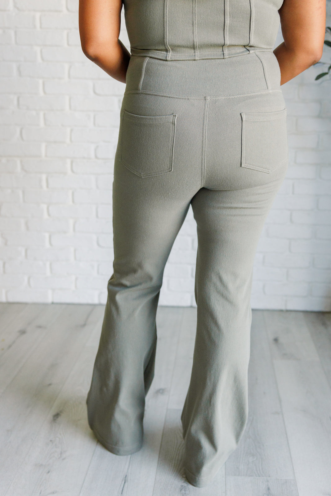 Twill Flared Crossover Waist Pants in dusty olive with a high V-waistline, medium-stretch fabric, flared legs, and functional front and back pockets.