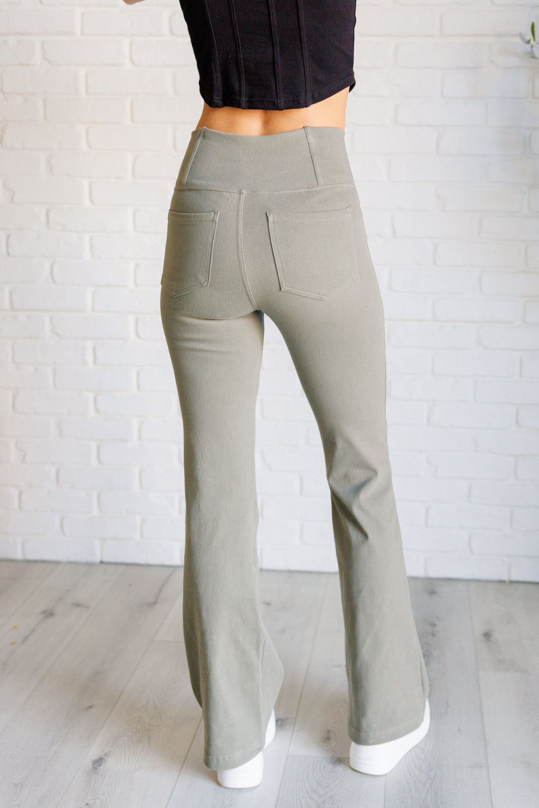 Twill Flared Crossover Waist Pants in dusty olive with a high V-waistline, medium-stretch fabric, flared legs, and functional front and back pockets.