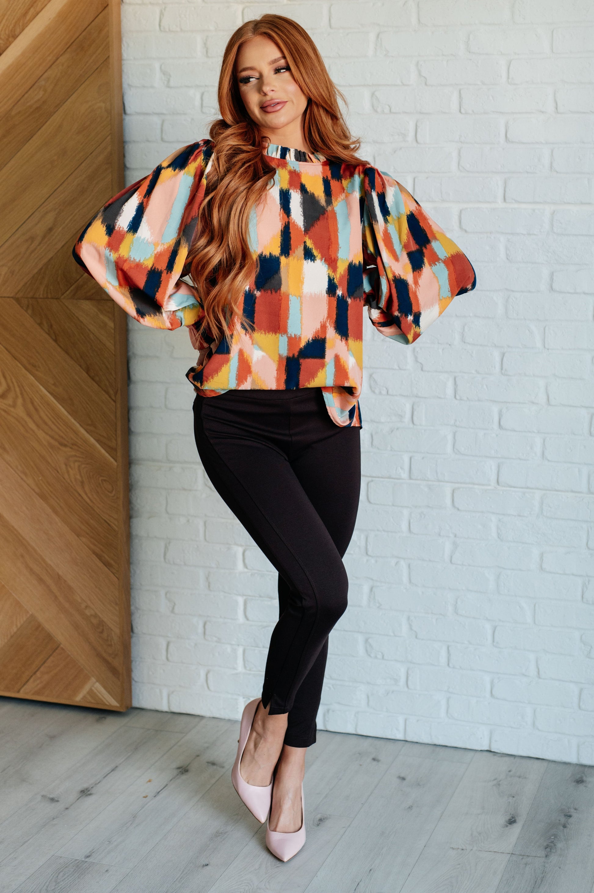 Padme Blouse featuring a bold mod print, ruffled neckline, and smocked elastic sleeve cuffs for a chic, vintage-inspired look with a modern twist.