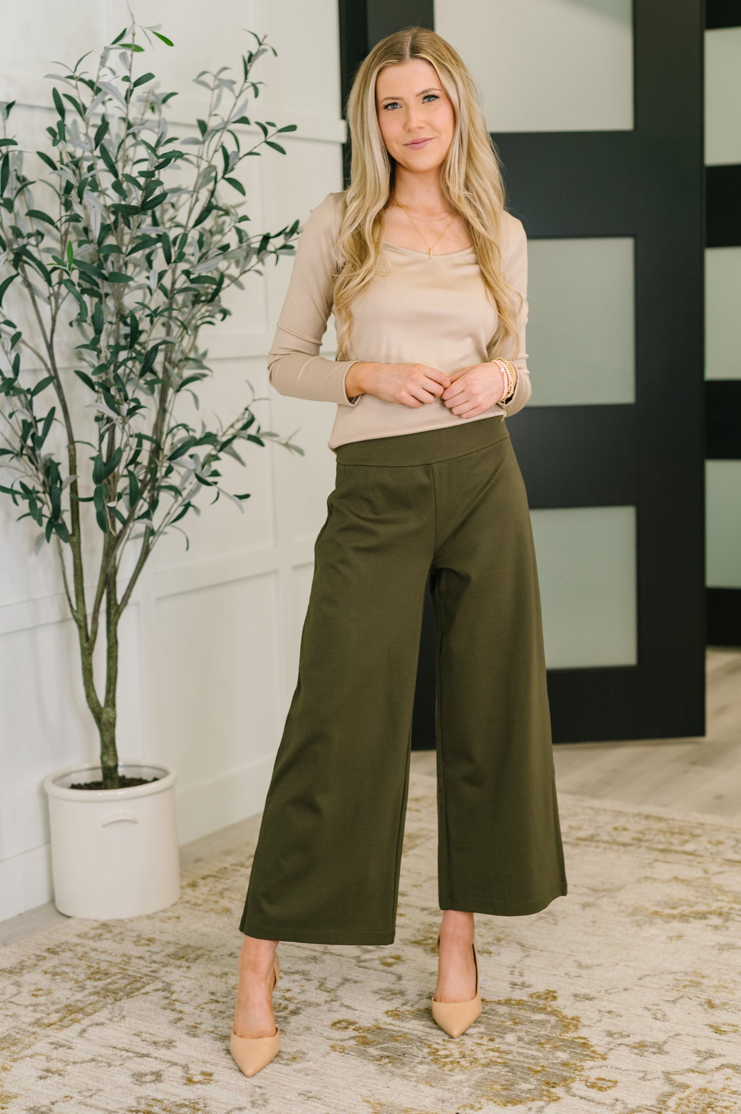 Model styled in Laura Basic Long Sleeve Top in Sand with wide-leg pants and heels.