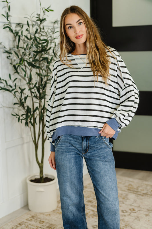 Front view of black and white striped crew neck pullover with denim trim.