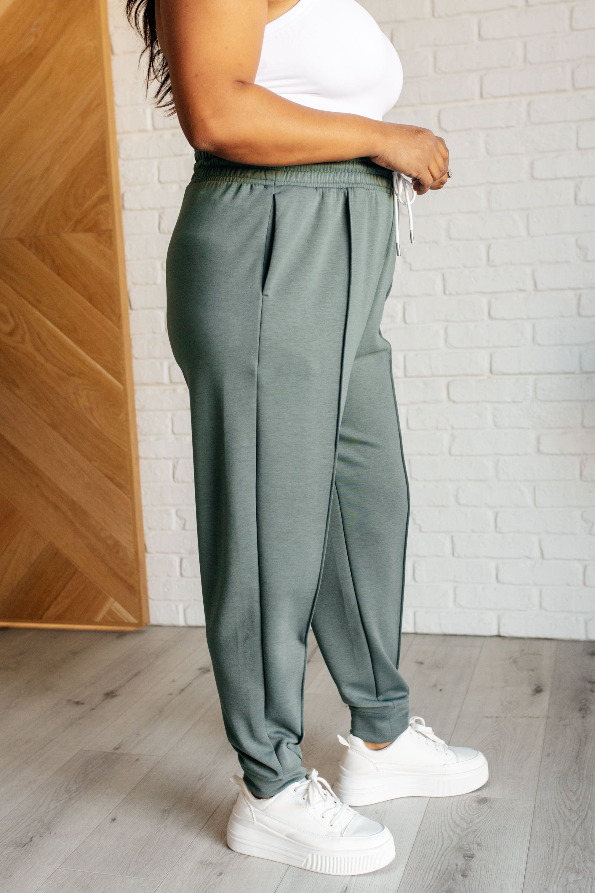 Center Seam Scuba Joggers in ash jade featuring a front seam, elastic waistline with functional drawstring, side pockets, and banded hem for a comfortable and stylish fit.