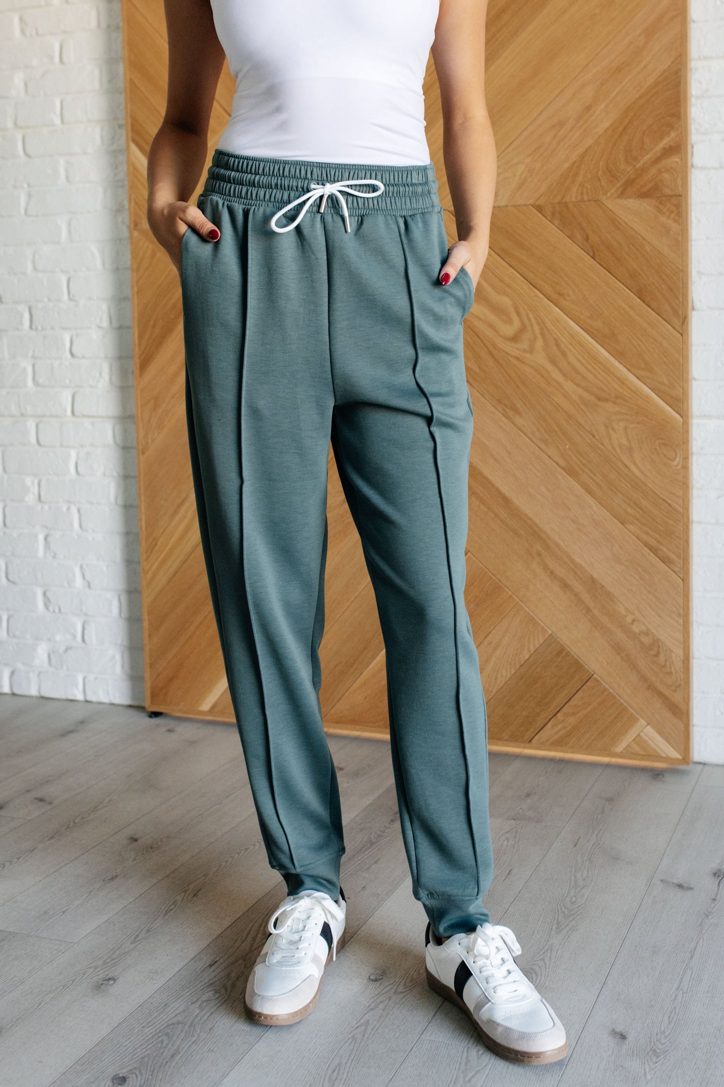 Center Seam Scuba Joggers in ash jade featuring a front seam, elastic waistline with functional drawstring, side pockets, and banded hem for a comfortable and stylish fit.