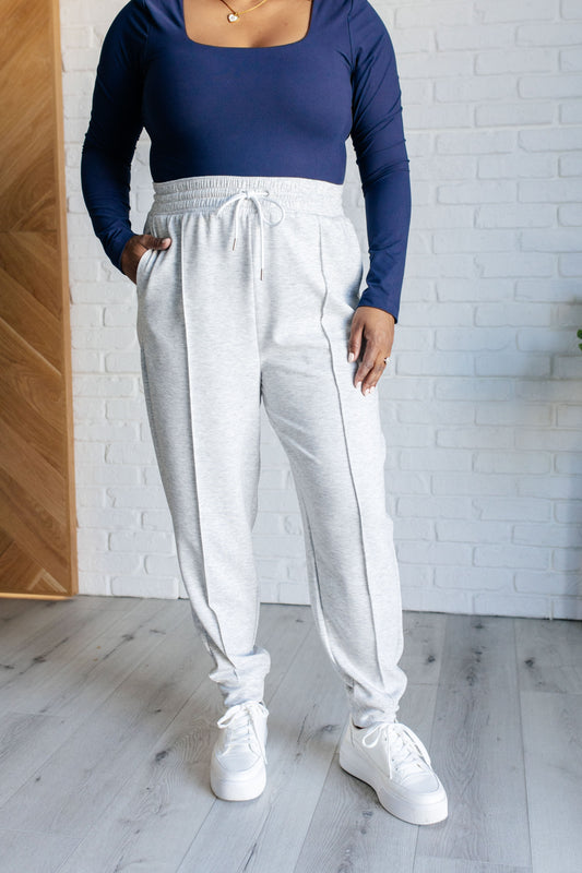 Center Seam Scuba Joggers in heather gray featuring a front seam, elastic waistline with functional drawstring, side pockets, and banded hem for a comfortable and stylish fit.